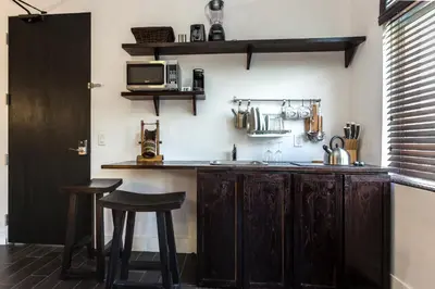 a kitchen with a counter with stools and a microwave at Vive Zen Queen Room in Miami