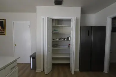 a kitchen with an open pantry with a black refrigerator at Airbnb rental in Miami