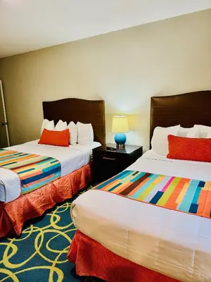 a hotel room with two beds with colorful pillows at Silver Seas Beach Resort in Fort Lauderdale