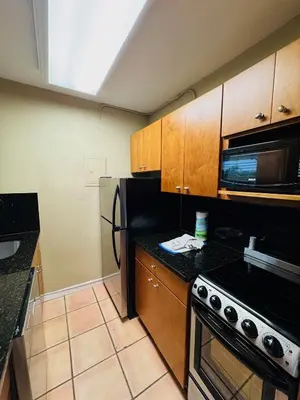 a kitchen with a black refrigerator and a microwave at Silver Seas Beach Resort in Fort Lauderdale