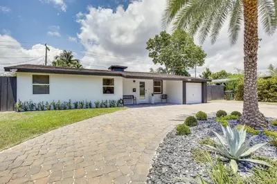 a house with a palm tree and a driveway at Fort Lauderdale Vacation Rental about 8 Mi to Beaches! in Fort Lauderdale