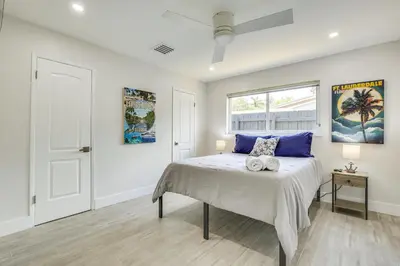 a bedroom with a bed with blue pillows and a window at Fort Lauderdale Vacation Rental about 8 Mi to Beaches! in Fort Lauderdale