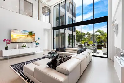 a living room with a large couch and a large window at Boardwalk Mansion in Fort Lauderdale