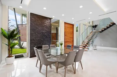 a dining room with a glass table and chairs at Modani Estates in Miami