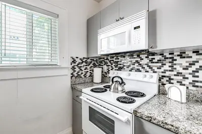 a kitchen with a white stove and a microwave at Comfy Little Havana Apt - Centrally located Hv2 in Miami