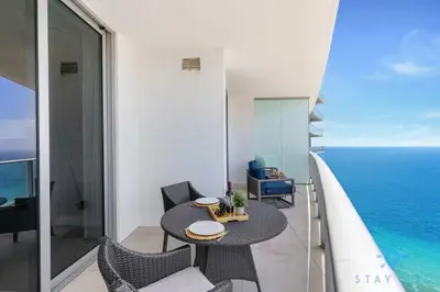 a balcony with a table and chairs and the ocean at Upper Level Penthouse - Amazing Views Beach & Intracoastal in Hollywood