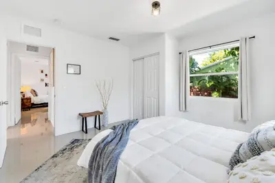 a white bedroom with a large bed and a window at Urban Seaside in Dania Beach