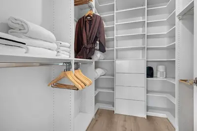 a walk in closet with white shelves and towels at 2-Story 3BD Brickell Penthouse Free Parking Heated Pool in Miami
