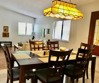 a dining table and chairs in a living room at Pool House in Tropical Miami in Miami
