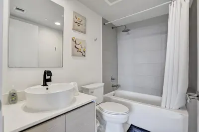 a white bathroom with a sink and a toilet at Lower Penthouse 3BD 3BA - Beach Pool Gym in Hallandale Beach