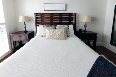 a white bed with a pillow with the word joy on it at 1bed 1bath Steps To Marina & Cocowalk In Grove in Miami