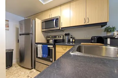 a kitchen with a stainless steel refrigerator and a sink at 1bed 1bath Steps To Marina & Cocowalk In Grove in Miami