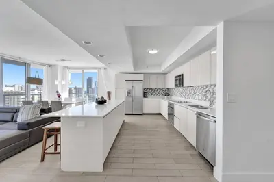a large white kitchen with a couch and a table at Modern Ocean View 3 Bedroom Condo Resort Amenities in Hallandale Beach