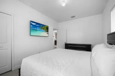 a white bedroom with a bed and a picture on the wall at Villa Coco Cozy Home Near Brickell Miami Beach in Miami