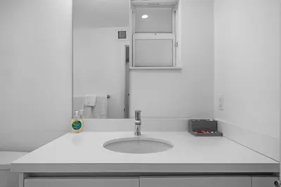 a white bathroom with a sink and a mirror at Villa Coco Cozy Home Near Brickell Miami Beach in Miami