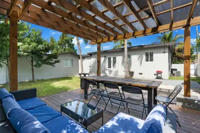 a patio with a blue couch and a wooden table at Villa Coco Cozy Home Near Brickell Miami Beach in Miami