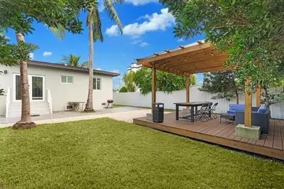 a wooden pergola with a table in a yard at Villa Coco Cozy Home Near Brickell Miami Beach in Miami