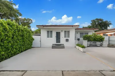 a white house with a driveway at Villa Mia Cozy Home in the heart of Miami in Miami