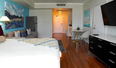 a bedroom with a bed and a living room with a table at Glamorous Bay View Studio In The Heart Of Grove in Miami