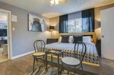 a bedroom with a bed with two chairs and a table at Private Pool and Patio Fort Lauderdale Home! in Fort Lauderdale