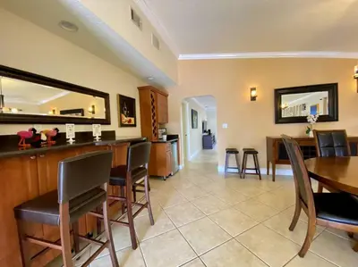 a living room with a bar and a dining room at Tropical Oasis home w Community Pool great area in Kendall