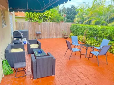 a patio with chairs and tables and a fence at Tropical Oasis home w Community Pool great area in Kendall