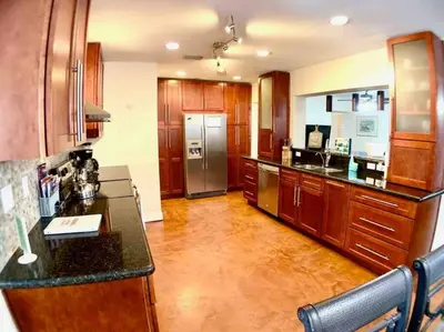 a kitchen with wooden cabinets and a stainless steel refrigerator at HOME AWAY FROM HOME Near Airport and Malls and Highways in South Miami