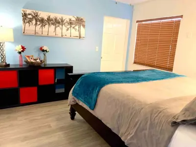 a bedroom with a bed and a window with palm trees at Home Sweet Home Near Malls and Airport and Hwy in South Miami