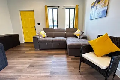 a living room with a couch and a yellow door at Sunny Delight Home Near Airport in Hollywood