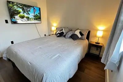 a bedroom with a large white bed with two lamps at Sunny Delight Home Near Airport in Hollywood