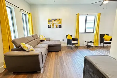a living room with a couch and chairs and windows at Sunny Delight Home Near Airport in Hollywood