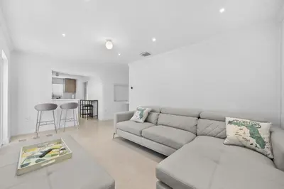 a white living room with a couch and a table at Villa Capri Cottage in the heart of Miami in Miami