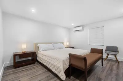 a bedroom with a bed and a desk and a chair at Villa Capri Cottage in the heart of Miami in Miami