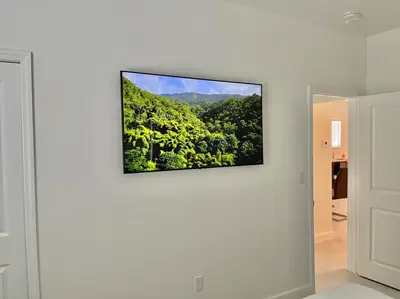 a flat screen tv hanging on a white wall at Villa Gia Large Home Near Brickell Miami Beach in Miami