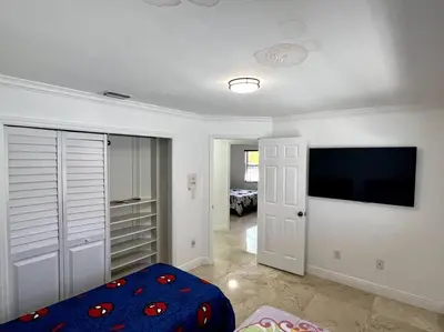 a living room with a tv and a bedroom at Sunny Getaway: Relaxing Miami Home in Tamiami