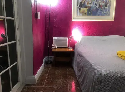 a bedroom with a bed and a table with a lamp at Miami House in Miami