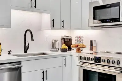 a white kitchen with white cabinets and a sink at Soleil @ Casa Del Sol in Fort Lauderdale