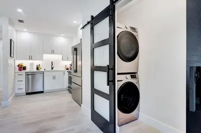 a kitchen with a washer and dryer on a wall at Soleil @ Casa Del Sol in Fort Lauderdale