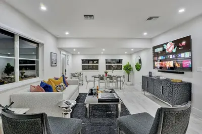 a living room with a couch and chairs and a tv at Soleil @ Casa Del Sol in Fort Lauderdale