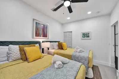 a living room with two beds and a ceiling fan at SOBE Monarch 1 - 2 BEDROOM 2 BATHROOM - MODERN APTS -WALK TO OCEAN DRIVE -2 INDEPENDENT 1 BEDROOM 1 BATHROOM APTS in Miami Beach