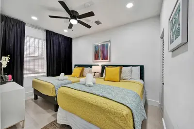 a bedroom with two beds and a ceiling fan at SOBE Monarch 1 - 2 BEDROOM 2 BATHROOM - MODERN APTS -WALK TO OCEAN DRIVE -2 INDEPENDENT 1 BEDROOM 1 BATHROOM APTS in Miami Beach