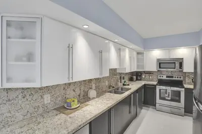 a large kitchen with white cabinets and appliances at Beautiful 1 1 Beach View 14 Floor in Hollywood