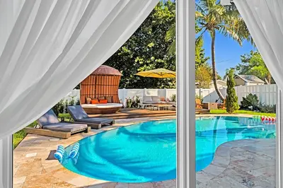a swimming pool with a gazebo viewed through a window at Luxury Hollywood Home, Heated Pool, Casino Nearby in Hollywood