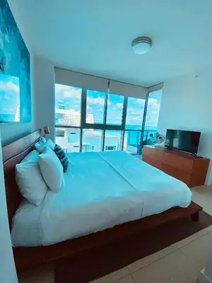 a bedroom with a large bed with a view of the ocean at Monte Carlo by Miami Ambassadors in Miami Beach