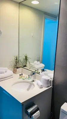 a bathroom with a sink and a large mirror at Monte Carlo by Miami Ambassadors in Miami Beach