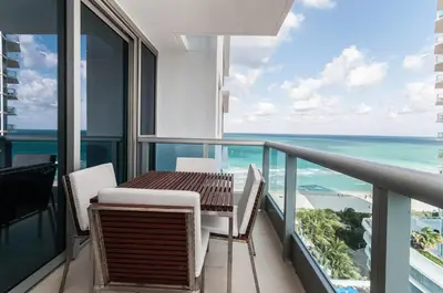 a balcony with a table and chairs and the ocean at Monte Carlo by Miami Ambassadors in Miami Beach