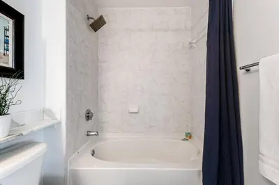a white bath tub with a blue shower curtain at Spectacular 2-Br Apartment 4 people 1107 in Miami