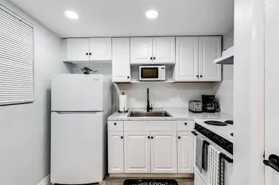 a kitchen with white cabinets and a white refrigerator at Loft style 1b Apt , Fast Wi-Fi Virg14 in Miami