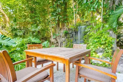 a wooden table and chairs in a garden at Relaxing Condo Hotel In The Grove, Free Parking in Miami