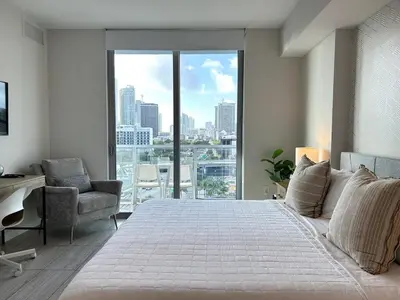 a bedroom with a large white bed and a window at Miami design district, view of the bay - city in Miami
